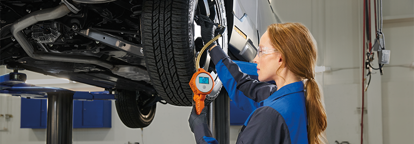 A Subaru technician checking tire pressure. | Sutherlin Subaru in Kingston TN